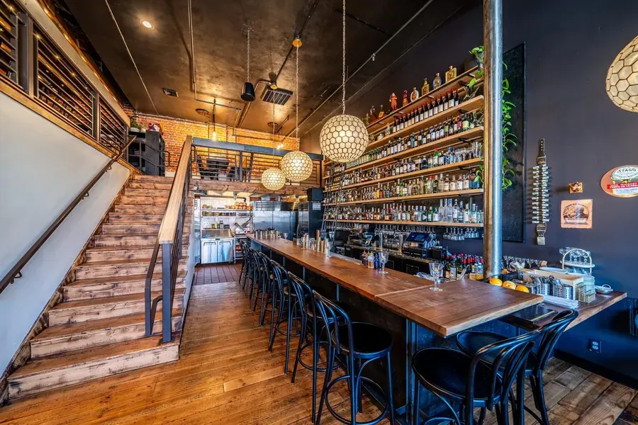 The long bar and wooden staircase inside Rancher Butcher Chef in Bend