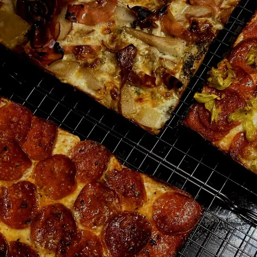 Square pepperoni pizzas cooling on racks at Rush’s Squares in Bend