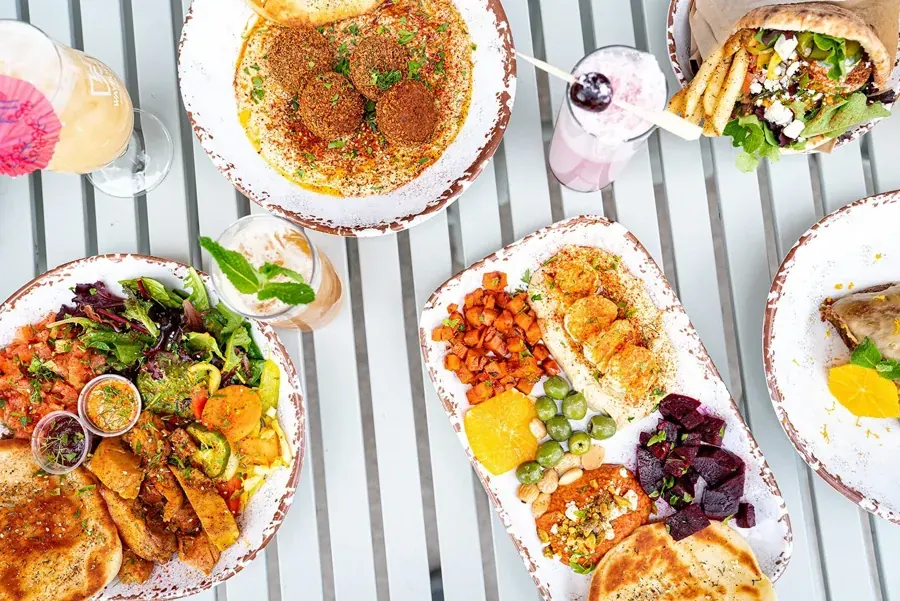 Falafel, hummus and salads on a striped table at Shimshon in The Grove, NorthWest Crossing