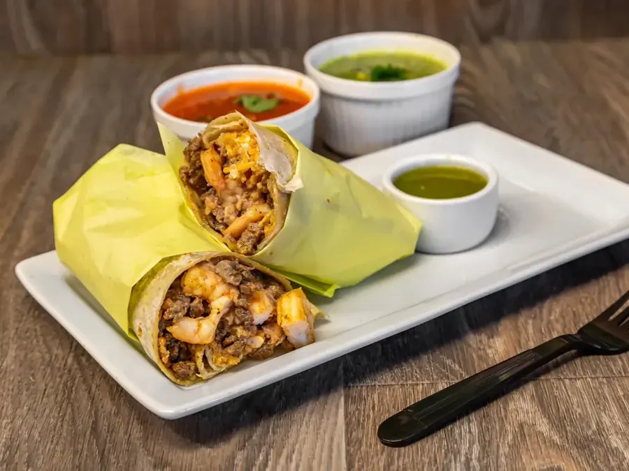 A burrito cut in half with salsas at Taco Salsa in Bend