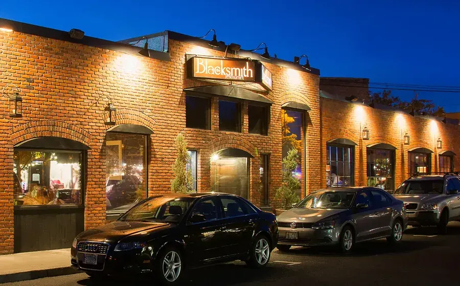 The brick exterior of The Blacksmith restaurant on Greenwood Avenue in Bend at dusk