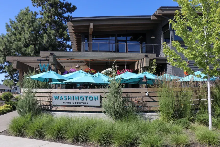 The patio with teal umbrellas at Washington Dining & Cocktails in NorthWest Crossing, Bend