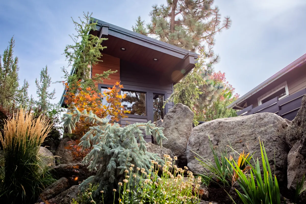 A modern outdoor sauna among boulders and pines by Redmond Spa, Stove & Sauna