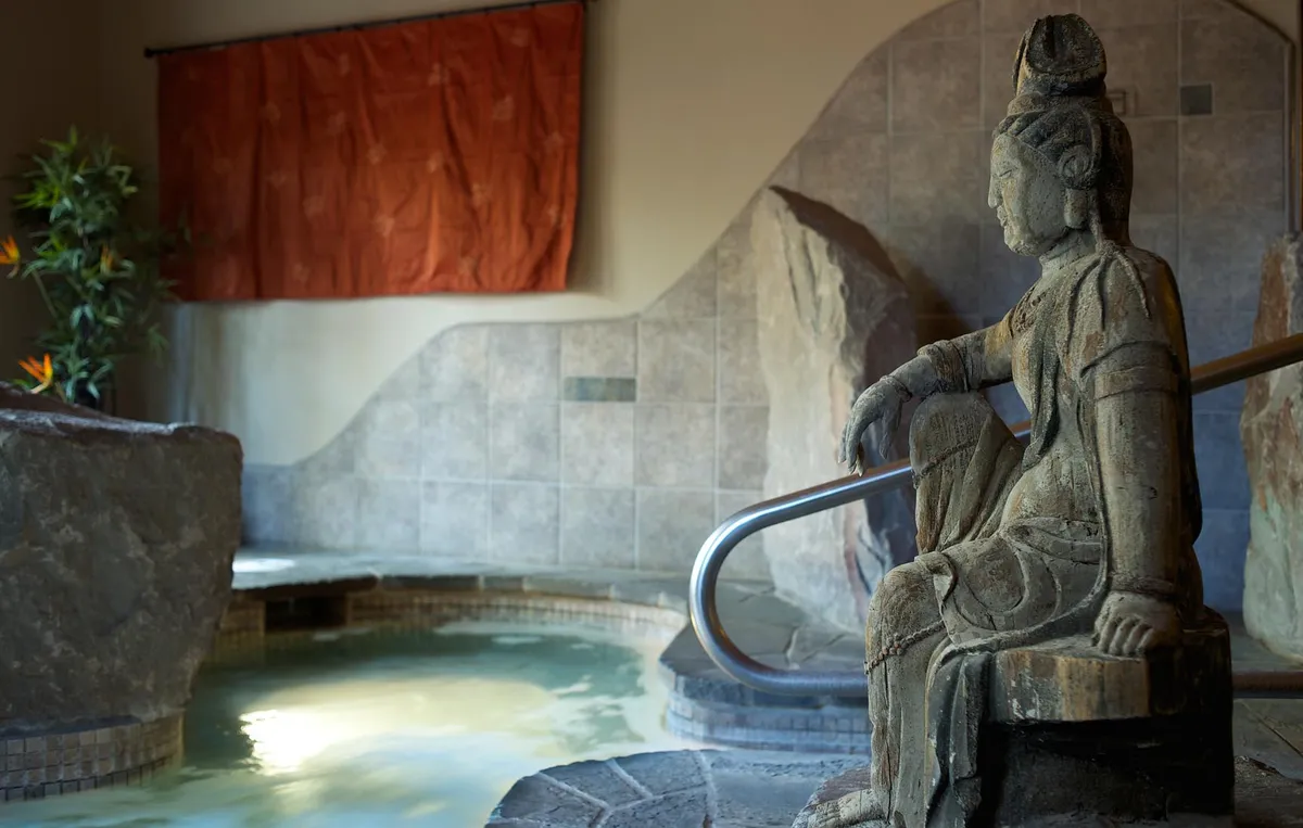 The thermal soaking tub and stone statue at Shibui Spa in Sisters
