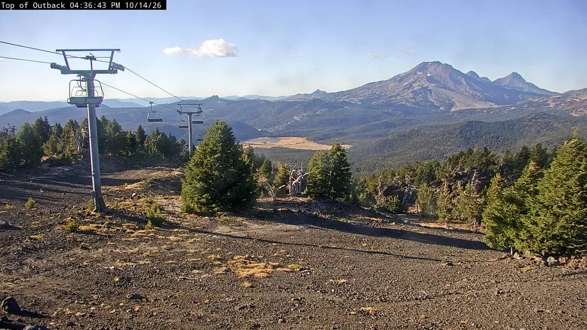 A chairlift on Mt. Bachelor in summer with a Cascade peak in the distance