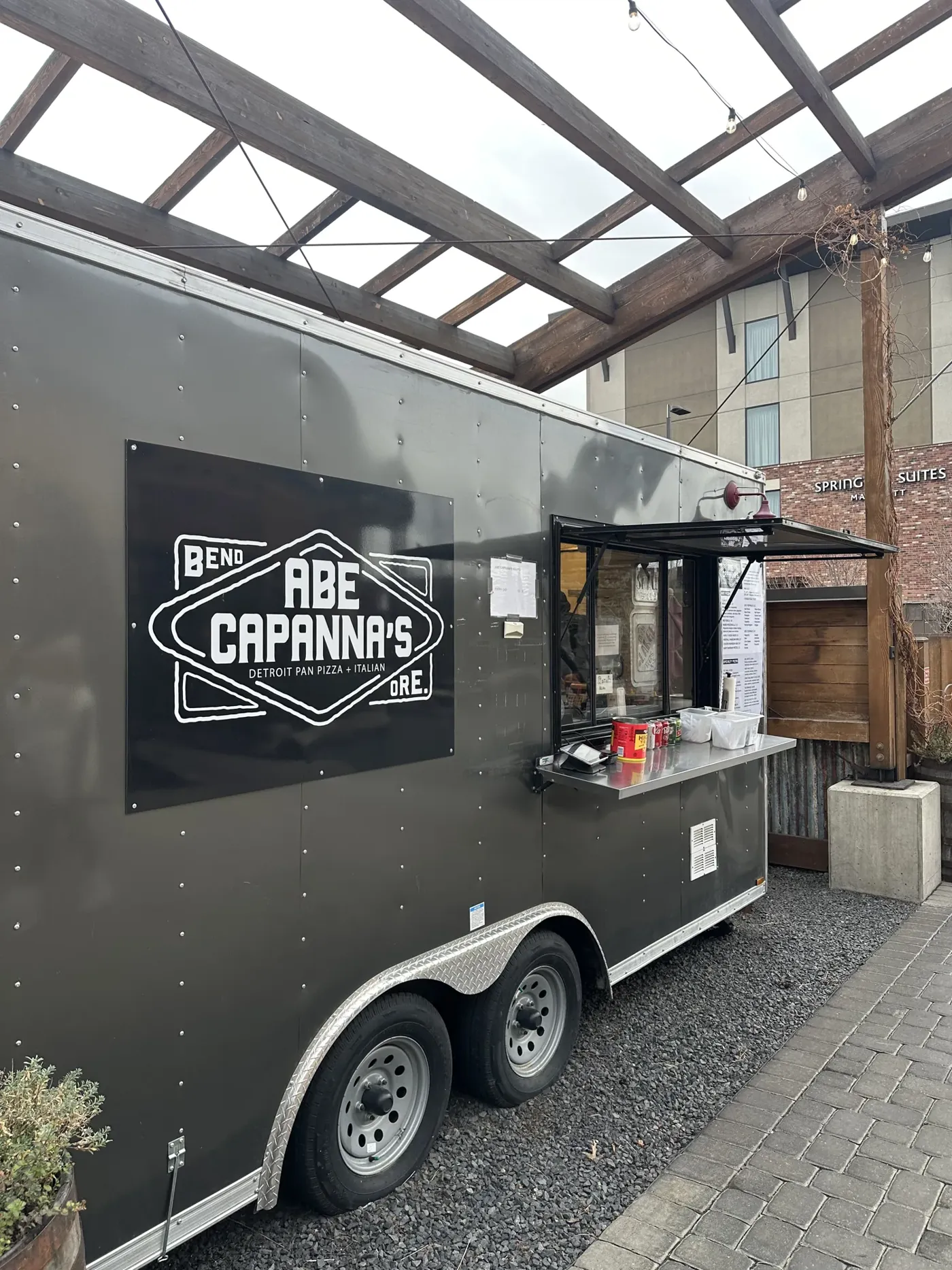 A food truck parked outside a building at a Bend food cart pod