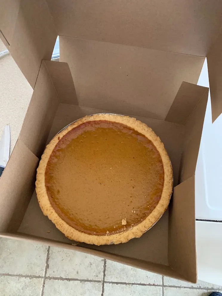 A pumpkin pie in a bakery box